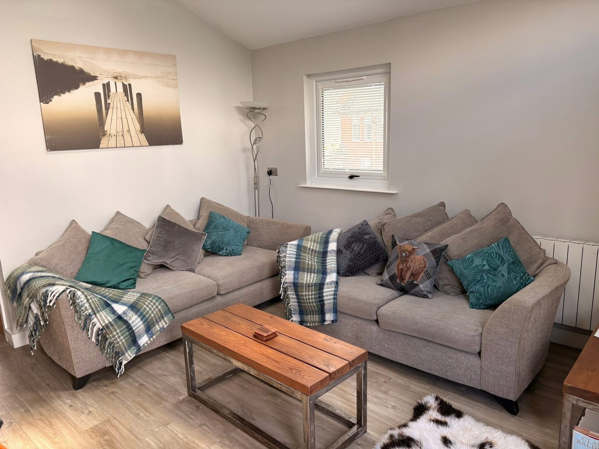 Corner sofa with sage and teal cushions in the lodge living room