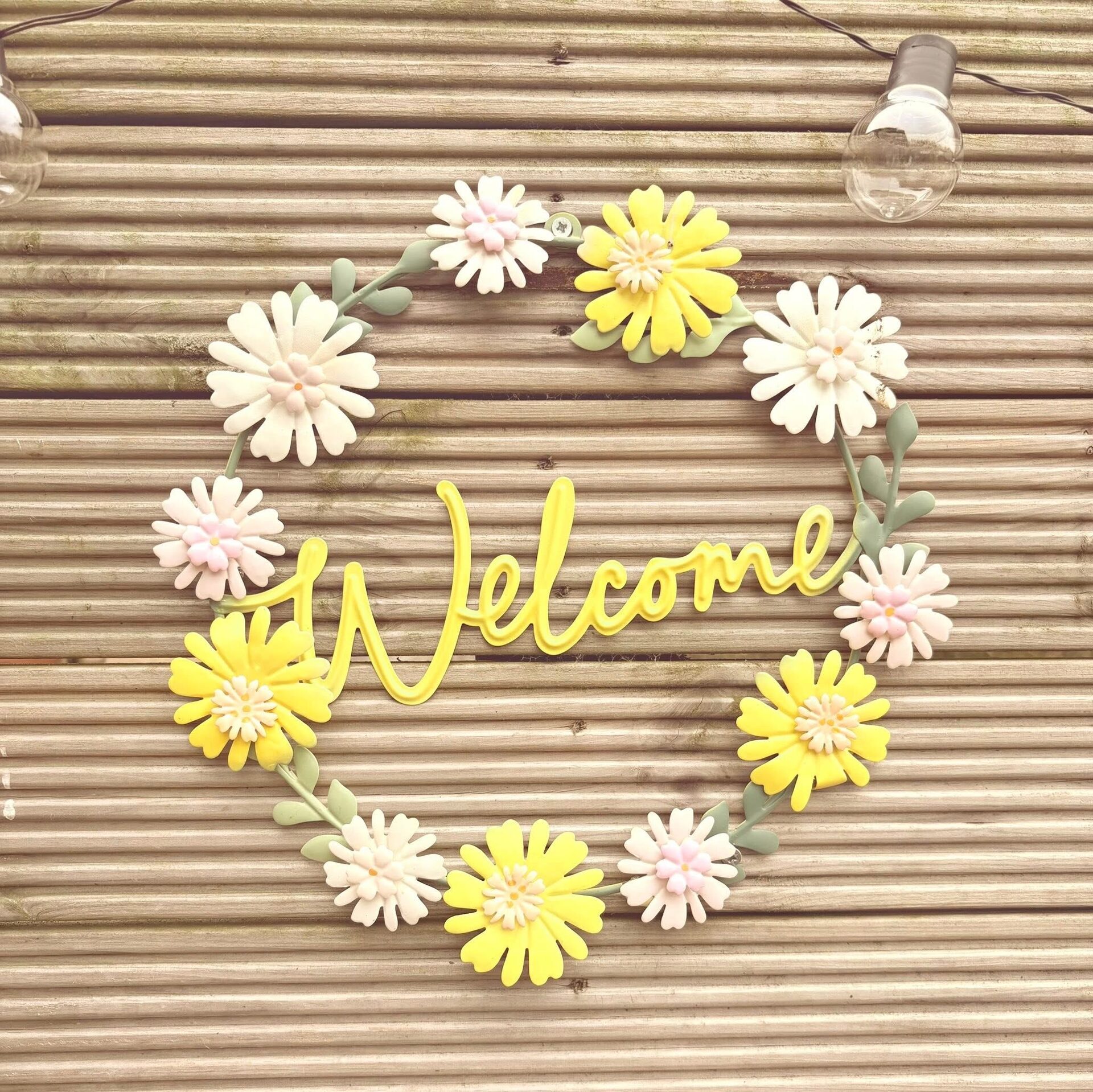 Welcome sign made of daisies on the lodge decking